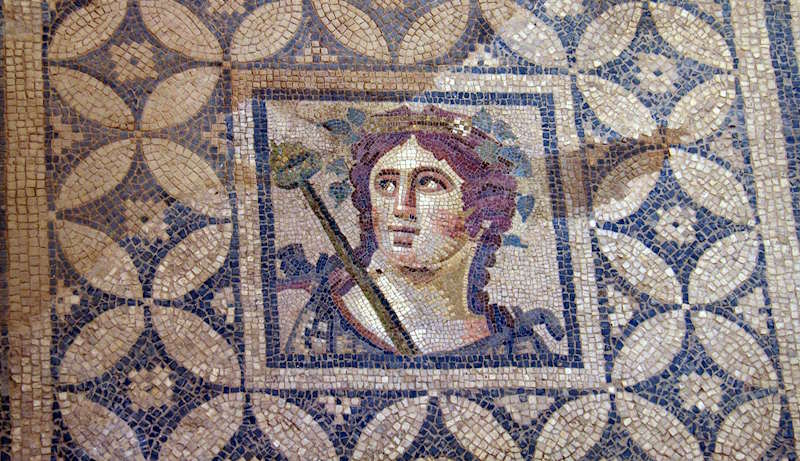 Mosaico romano con un rostro rodeado de teselas azules y blancas en Éfeso