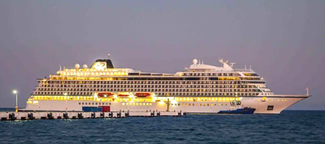 Crucero iluminado atracado al anochecer en el puerto de Kuşadası
