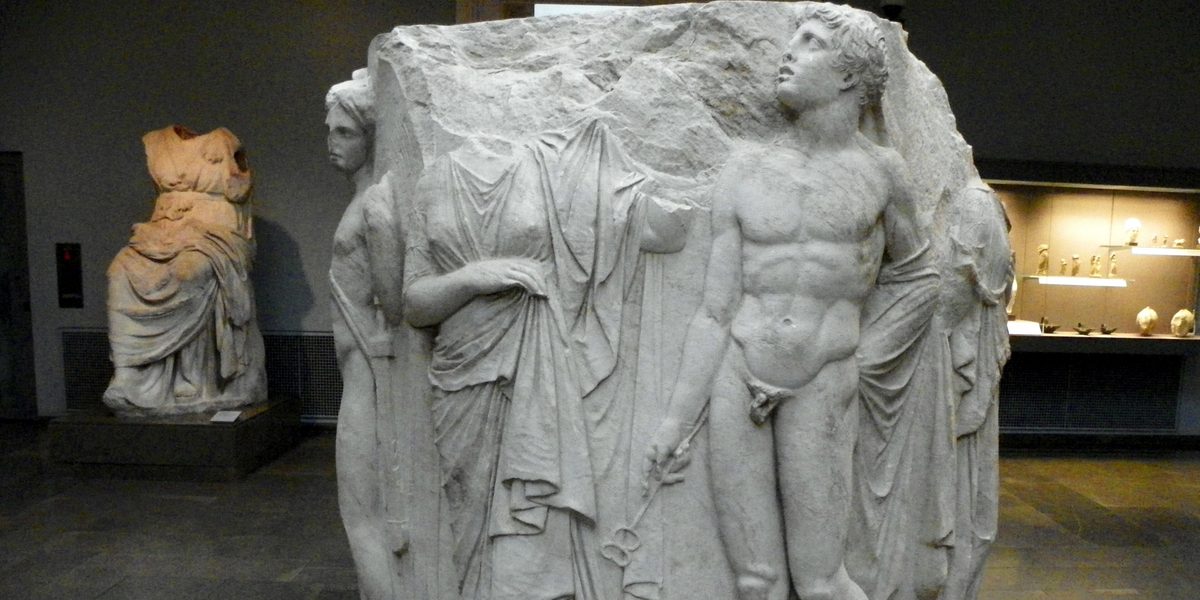 Tambor de columna esculpido del Templo de Artemisa reconstruido, con figuras en relieve y Hermes desnudo con el caduceo, expuesto en una sala del Museo Británico